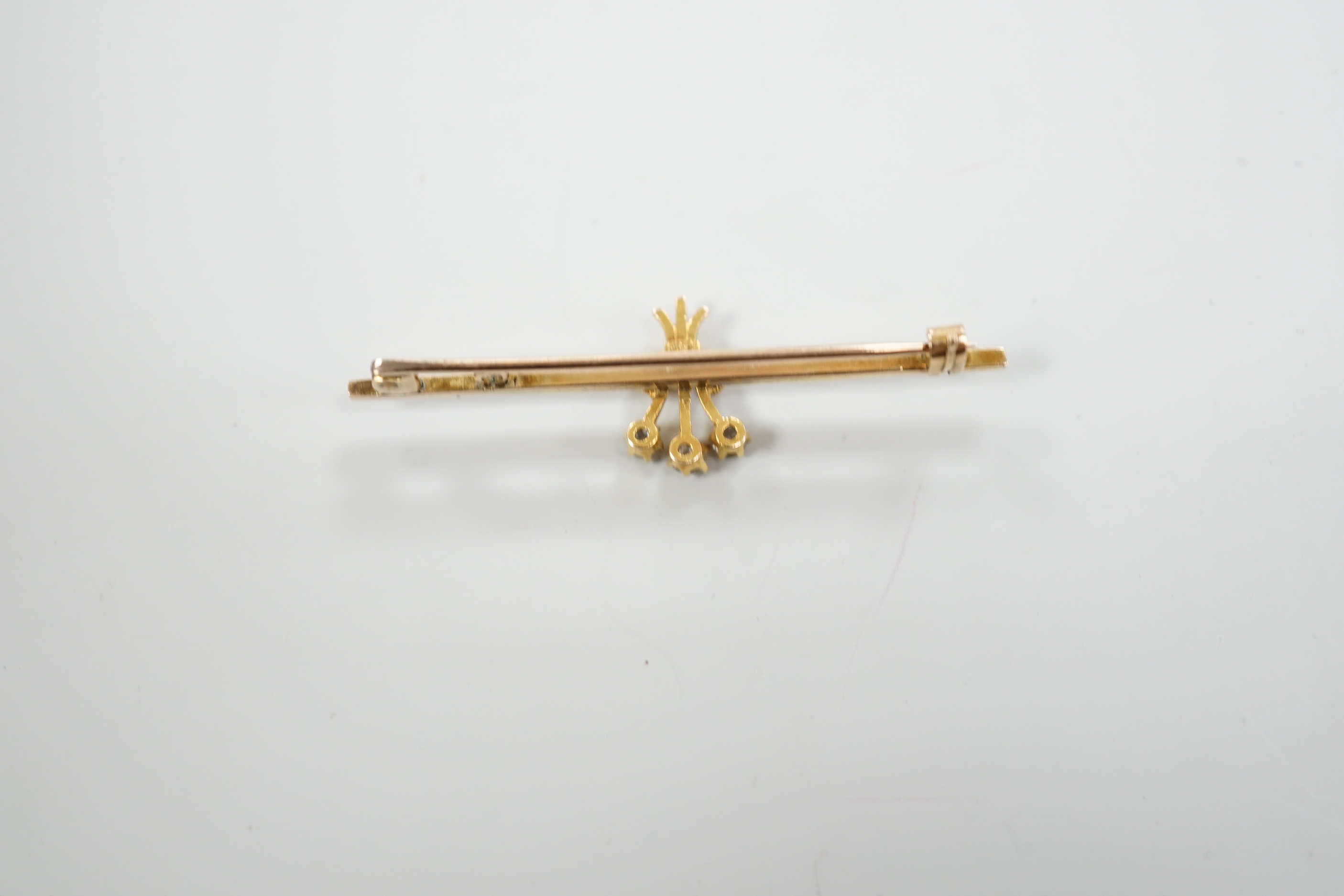 An Edwardian yellow metal and three stone diamond set bar brooch, 46mm, gross weight 2.5 grams.